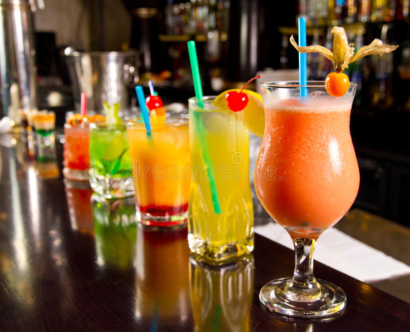 Beautiful looking Tropical cocktails lined up along bar top.