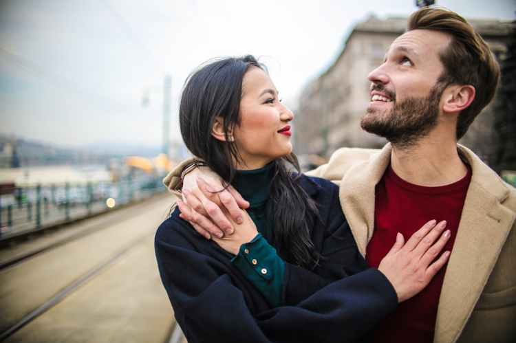 Happiness image of young woman and man embraced and smiling at each.